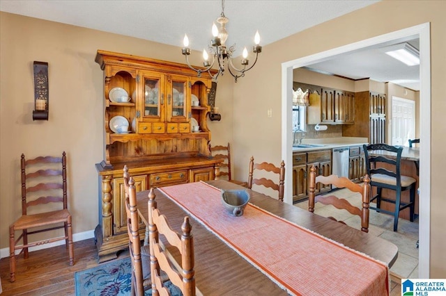 dining space with a chandelier, wood finished floors, and baseboards