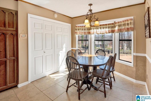 dining space featuring baseboards, light tile patterned floors, an inviting chandelier, and crown molding