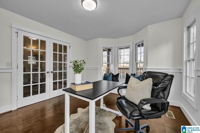 home office with a wealth of natural light, french doors, wood finished floors, and visible vents