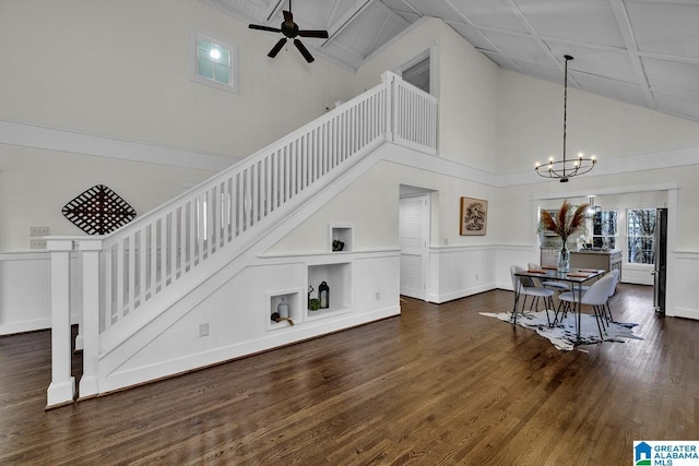 living area with high vaulted ceiling, stairway, wood finished floors, and ceiling fan with notable chandelier