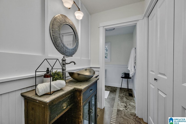 bathroom featuring marble finish floor, a wainscoted wall, and vanity