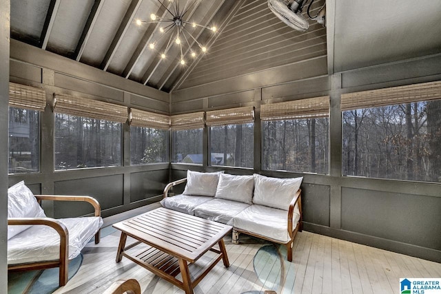 sunroom featuring lofted ceiling with beams and a notable chandelier