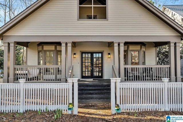 view of front of property featuring french doors, a porch, and a fenced front yard