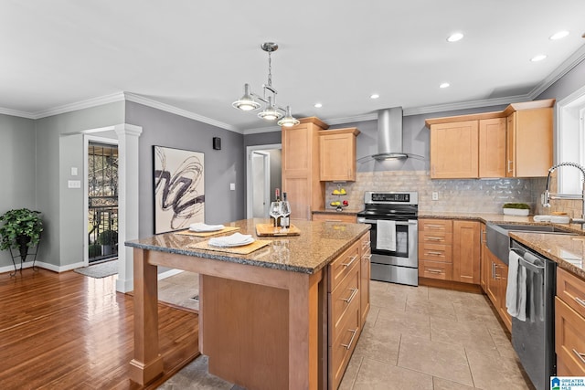 kitchen with a center island, a sink, stainless steel appliances, wall chimney range hood, and backsplash