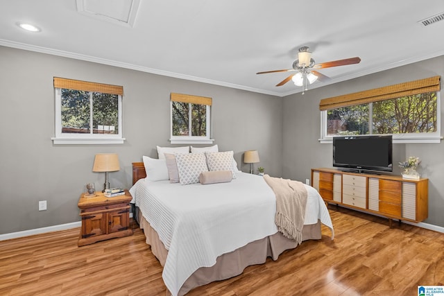 bedroom featuring multiple windows, visible vents, and crown molding