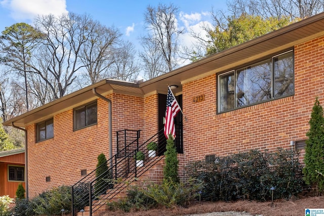 view of front of home featuring crawl space and brick siding