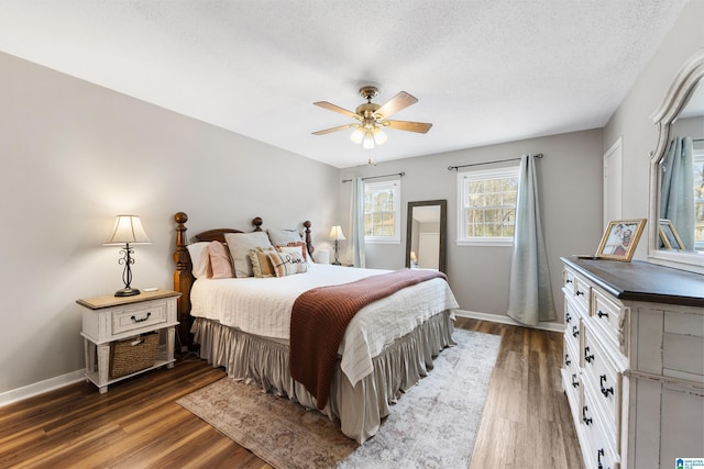 bedroom with a ceiling fan, a textured ceiling, baseboards, and wood finished floors