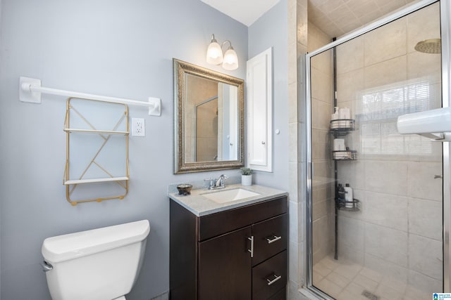 full bath with a stall shower, vanity, and toilet