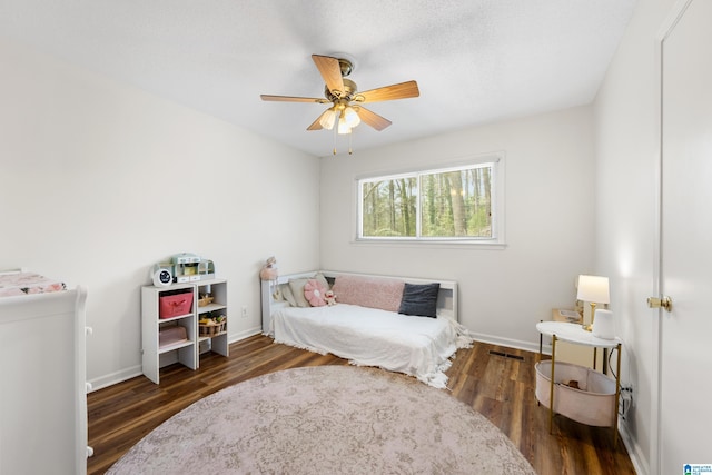 bedroom featuring ceiling fan, wood finished floors, and baseboards