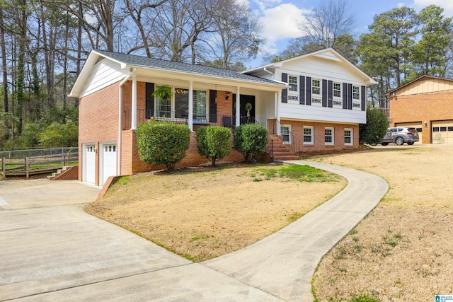 tri-level home featuring a garage, driveway, and brick siding