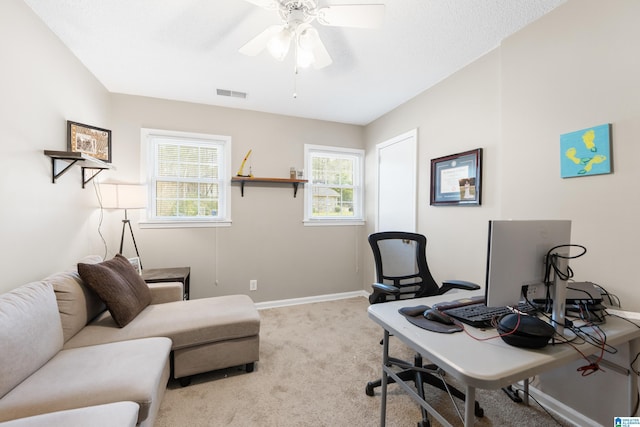 carpeted office space featuring ceiling fan, visible vents, and baseboards