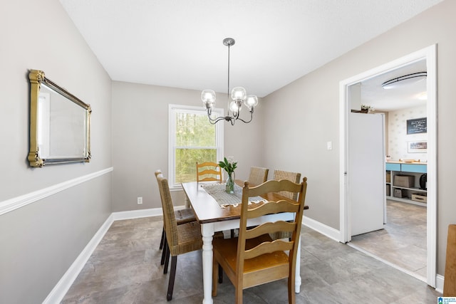 dining space featuring an inviting chandelier and baseboards