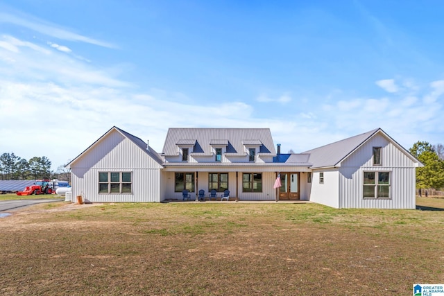 view of front of house featuring metal roof, board and batten siding, and a front yard