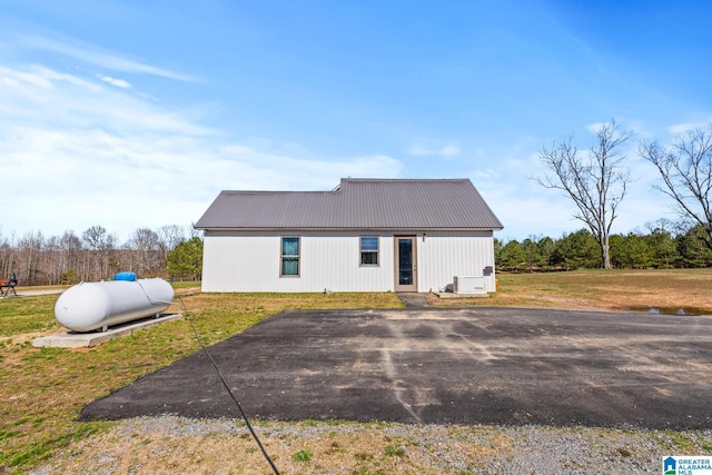 exterior space with metal roof and a lawn