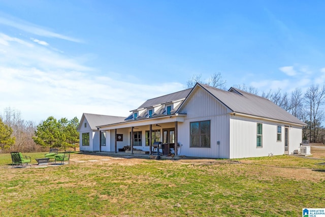 back of property with metal roof, a lawn, a ceiling fan, and a patio area