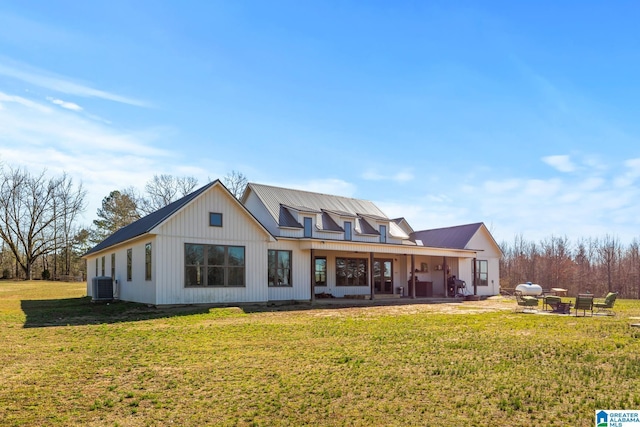 view of front facade featuring a front lawn, central air condition unit, a patio area, and metal roof