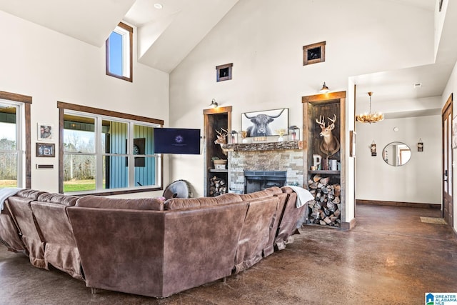 living room with a stone fireplace, a notable chandelier, concrete flooring, and high vaulted ceiling