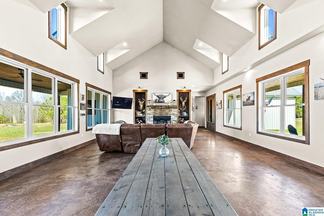 interior space with a stone fireplace, plenty of natural light, and vaulted ceiling