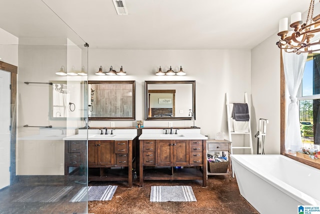 bathroom featuring a sink, visible vents, a freestanding bath, and two vanities