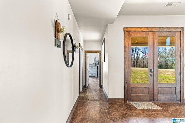 foyer entrance featuring visible vents, french doors, finished concrete flooring, and baseboards