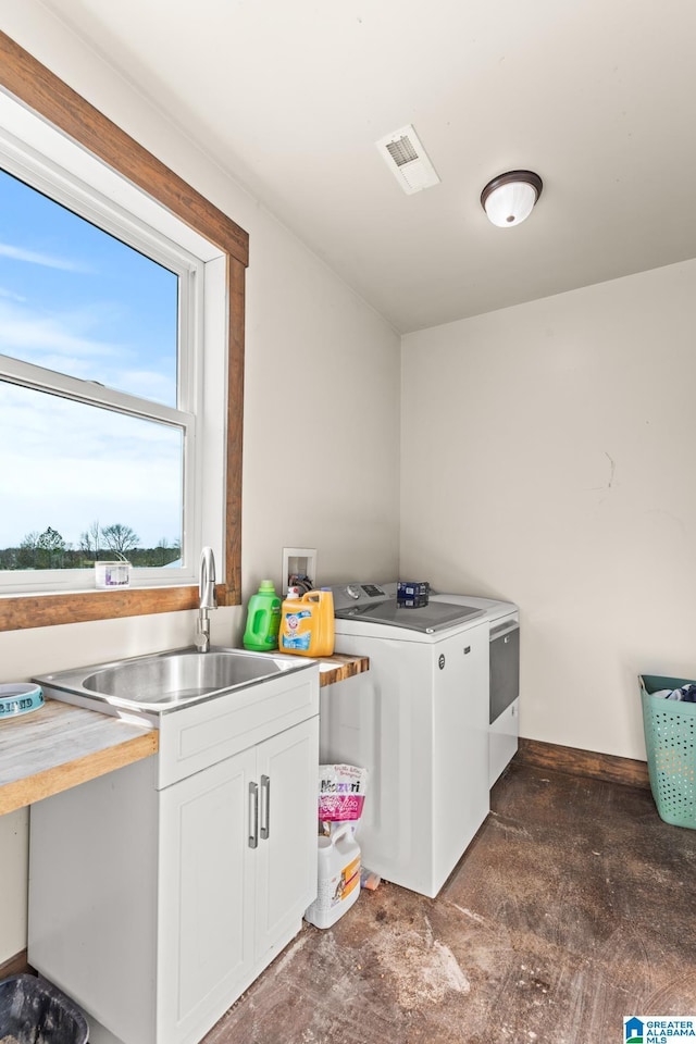 laundry area with a sink, visible vents, cabinet space, and separate washer and dryer