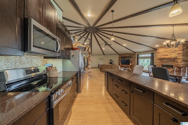 kitchen with lofted ceiling with beams, a fireplace, stainless steel appliances, and open floor plan