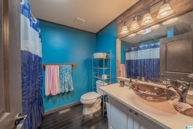 bathroom featuring toilet, wood finished floors, vanity, visible vents, and a shower with curtain