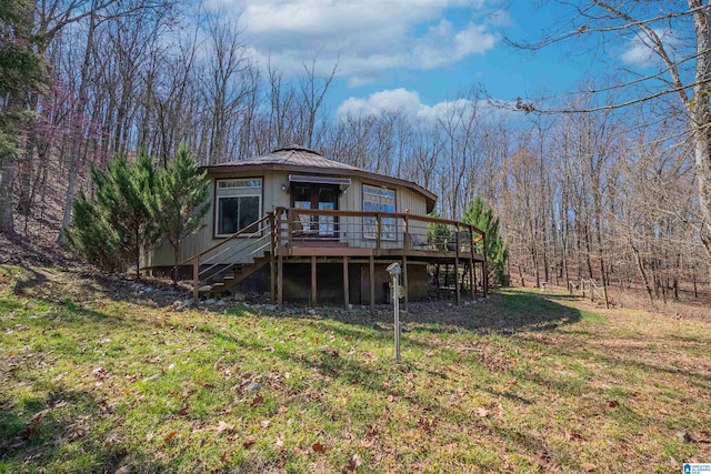 back of house featuring metal roof, stairway, a wooden deck, and a lawn