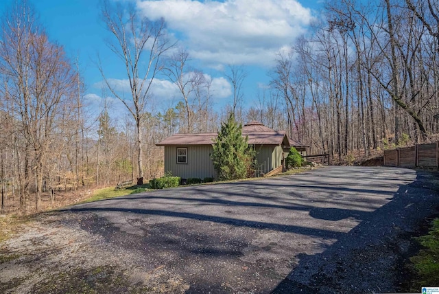 view of property exterior with driveway and fence