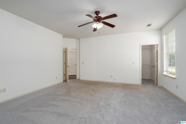 empty room featuring visible vents, ceiling fan, light carpet, and baseboards