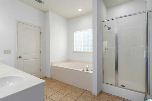 bathroom featuring a sink, a stall shower, a garden tub, and tile patterned floors