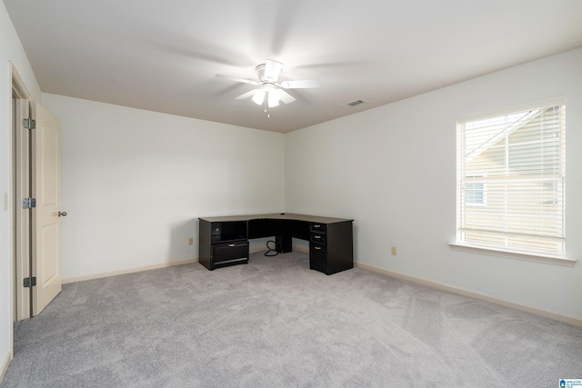 office featuring baseboards, ceiling fan, visible vents, and light colored carpet