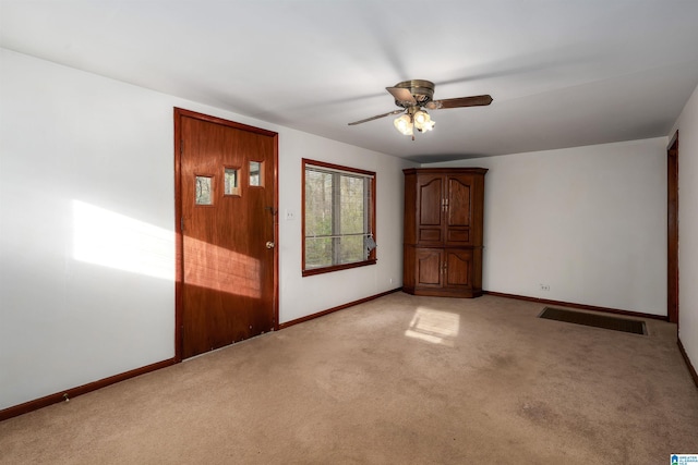 interior space featuring a ceiling fan, light colored carpet, visible vents, and baseboards