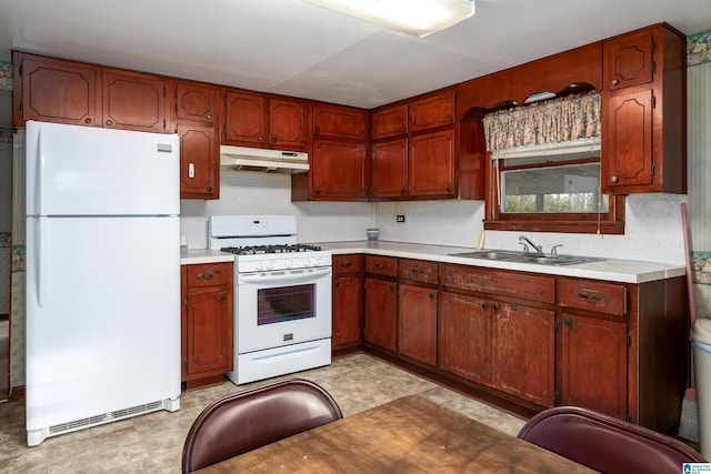 kitchen with light floors, light countertops, a sink, white appliances, and under cabinet range hood