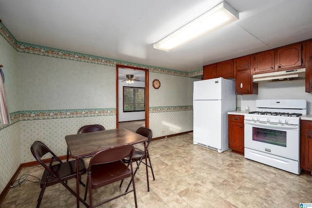 kitchen featuring light countertops, white appliances, under cabinet range hood, baseboards, and wallpapered walls