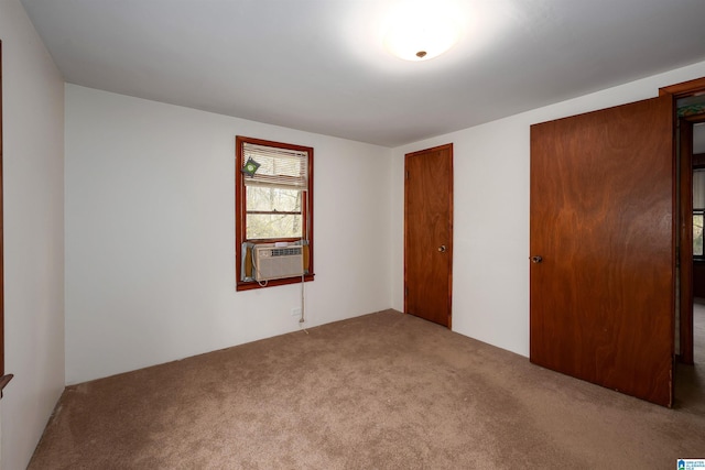 unfurnished bedroom featuring cooling unit and carpet flooring