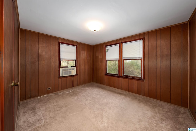 spare room featuring wood walls, cooling unit, and carpet flooring