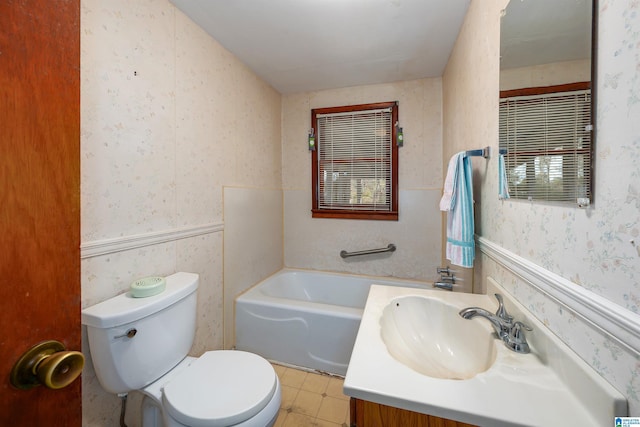 full bathroom featuring a wainscoted wall, wallpapered walls, toilet, vanity, and a bath