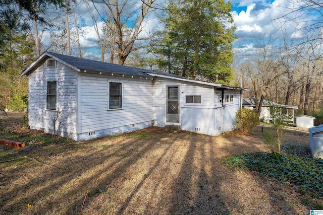 back of property featuring crawl space and a yard