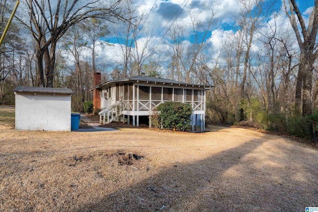 back of property with a sunroom and a chimney