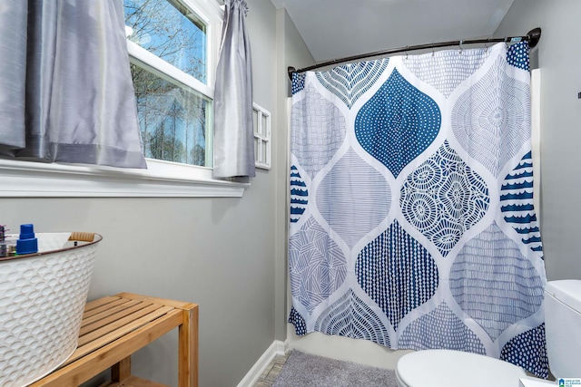 bathroom with curtained shower and toilet