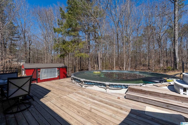 wooden terrace featuring a forest view and a covered pool