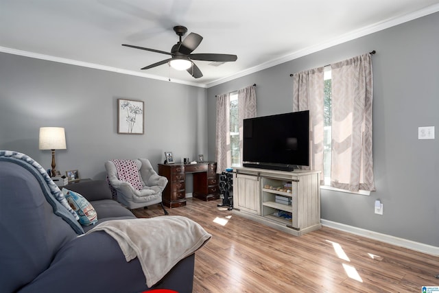 living room with light wood-style floors, ceiling fan, baseboards, and crown molding