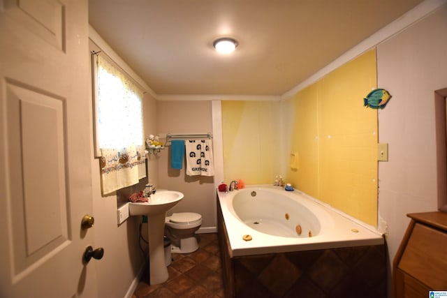 bathroom featuring ornamental molding, a jetted tub, a sink, and toilet