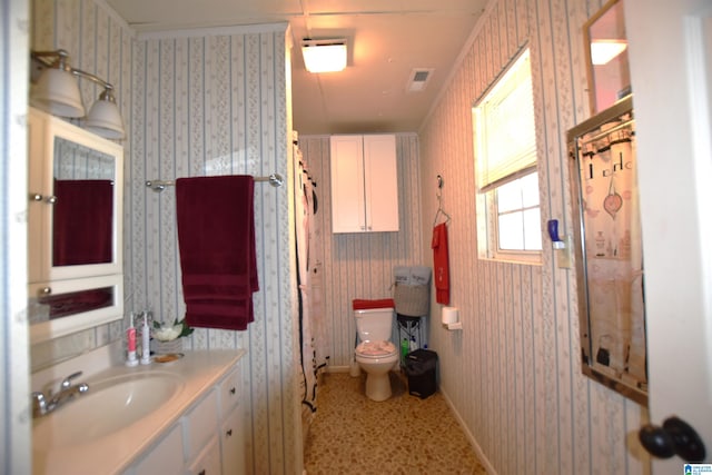 bathroom featuring visible vents, toilet, and wallpapered walls