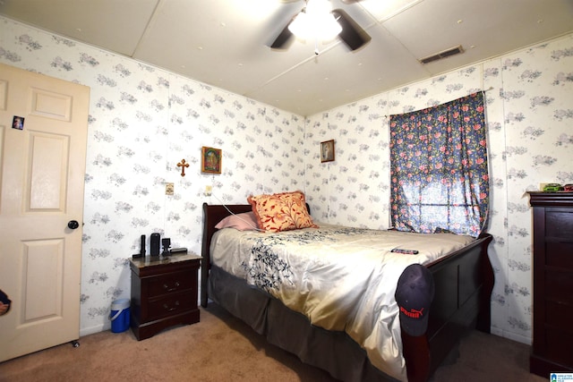 carpeted bedroom with wallpapered walls, ceiling fan, visible vents, and baseboards