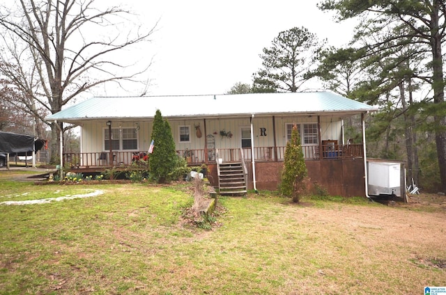 view of front of house with covered porch, metal roof, and a front lawn