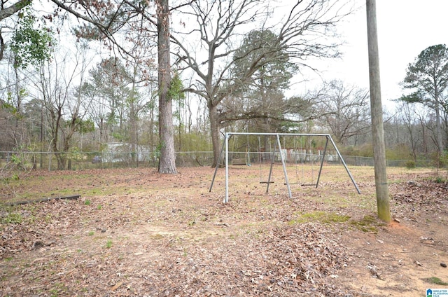 view of yard with a carport, playground community, and fence