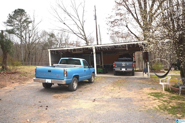 view of vehicle parking with driveway and a carport