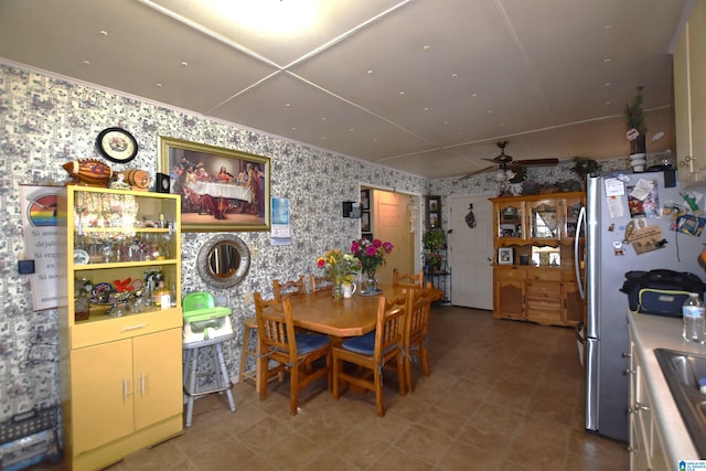 dining area featuring a ceiling fan and wallpapered walls